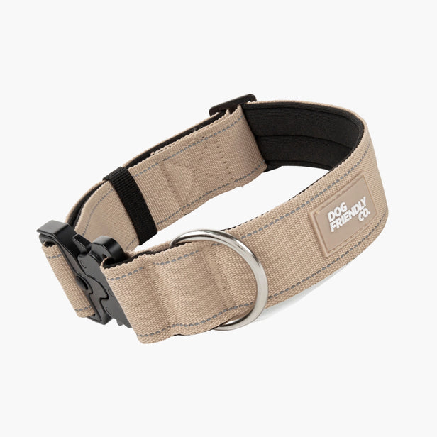 Close-up of the heavy-duty buckle and metal D-ring on a brown tactical dog collar.